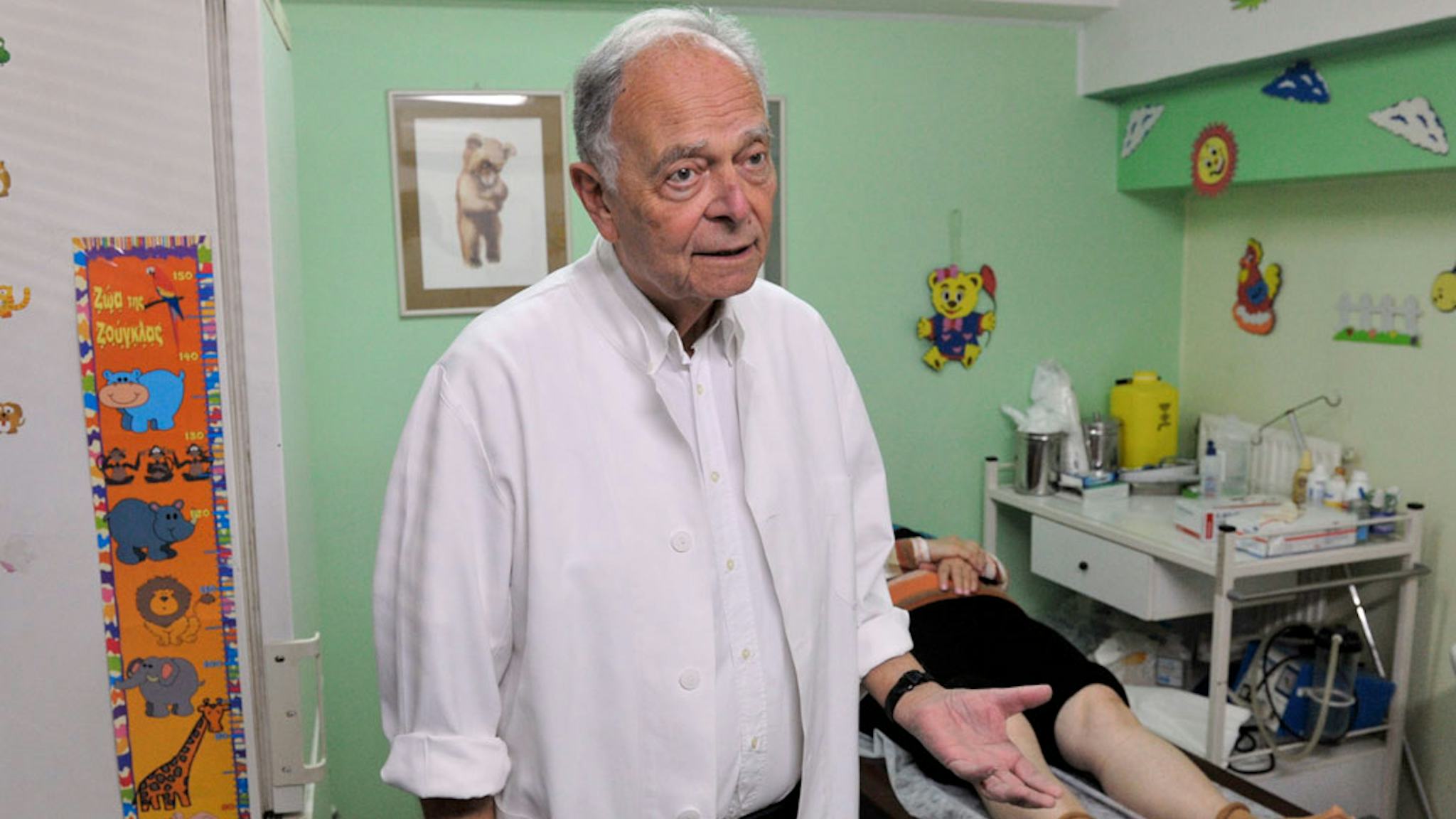 George Nikolakakis är pensionerad läkare men arbetar på Läkare i Världens mottagning flera dagar i veckan. Kvinnan på britsen bakom honom lider av artros. Patienterna är allt värre däran när de kommer till mottagningen, konstaterar han.