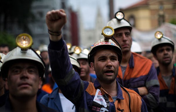 Kolgruvearbetaren Alejandro Santiago skanderar traditionella gruvarbetare under en protestmarch i Langreo nära Oviedo i Spanien på måndagen.