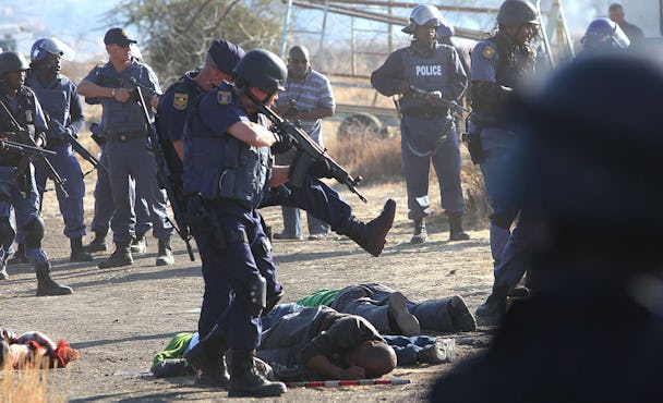 Polis omringar strejkande gruvarbetare efter att ha öppnat eld mot en folkmassa vid platinagruvan Lonmin nära Rustenburg i Sydafrika.