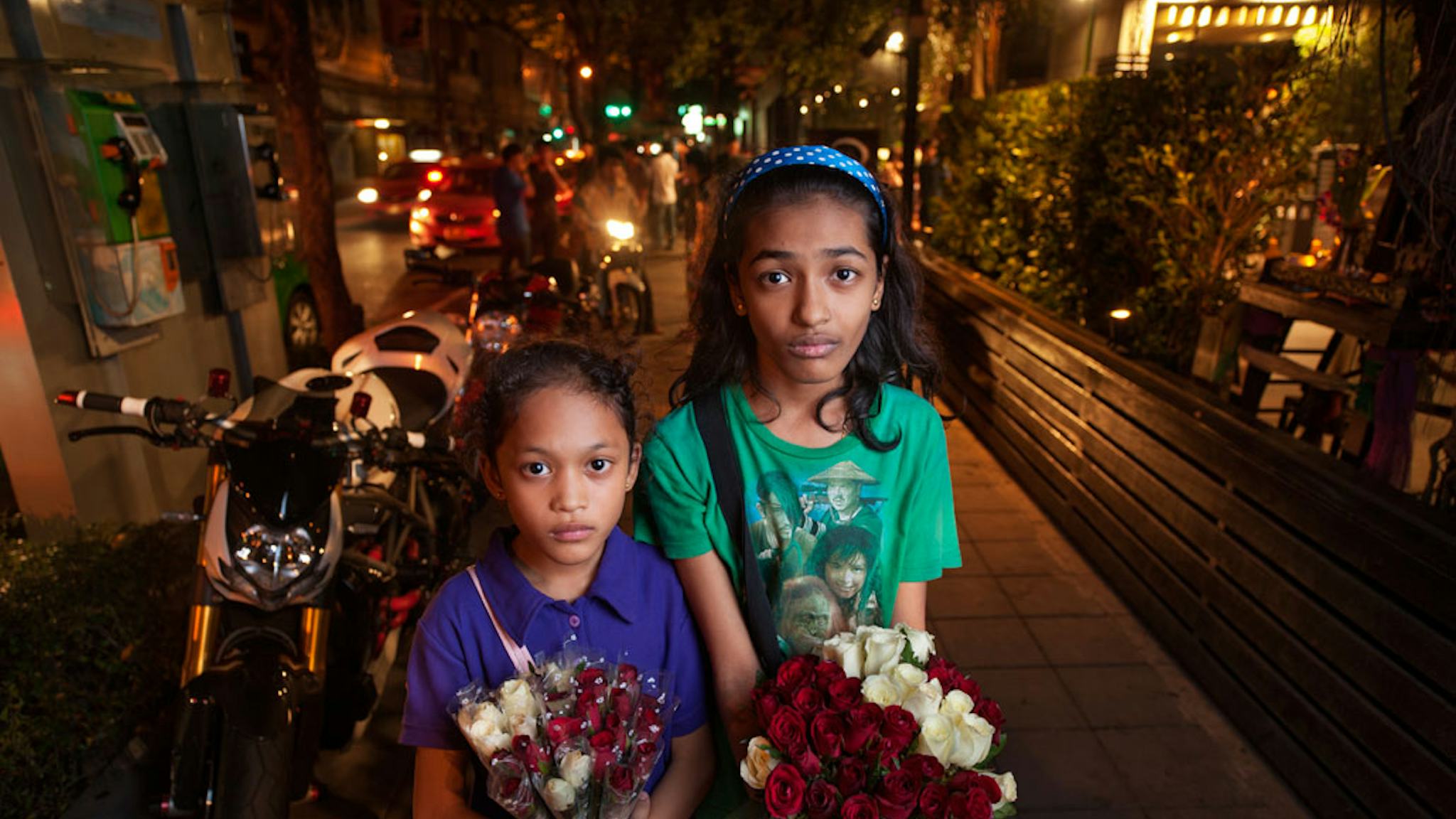 Please buy roses! Bibi, 8, och hennes syster Losia, 11, som inte vill säga sitt efternamn, hjälper till att försörja sin familj i nattklubbsmeckat, där de säljer rosor och tjänar ­ungefär 30 kronor vardera varje natt. Vännerna i deras ålder sover när flickorna är ute på gatorna och jobbar hårt.