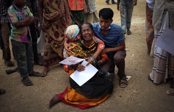 En sörjande kvinna i Dhaka tröstas efter att ha identifierat kroppen av dottern, som omkom när en niovåningsbyggnad rasade i slutet av april.