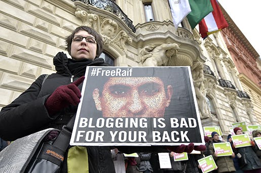En demonstrant håller upp en bild på den saudiske bloggaren Raif Badawi i Wien. Foto: AP/Hans Punz