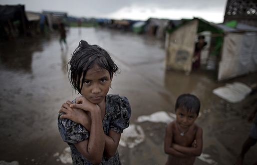 In this June 26, 2014 photo, a girl, self-identified as Rohingya, stands close to her family's tent house at Dar Paing camp for refugees, suburbs of Sittwe, Western Rakhine state,. Photo: AP /Gemunu Amarasinghe