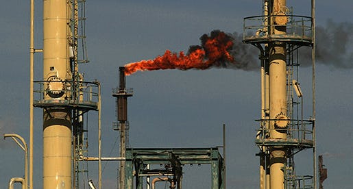 Fire shoots from a chimney at the Dura oil refinery outside Baghdad Saturday Feb. 22 2003. Iraq's oil reserves are the second largest in the world, after Saudi Arabia. (AP PHOTO/Jerome Delay)