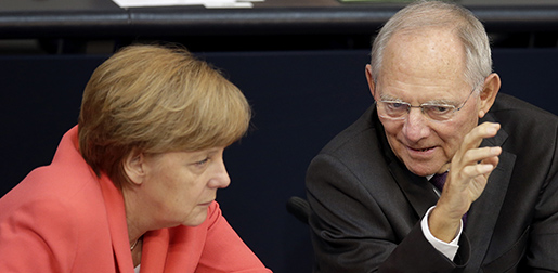 German Chancellor Angela Merkel, left, and German Finance Minister Wolfgang Schaeuble, right, talk during a meeting of the German federal parliament, Bundestag, in Berlin, Germany, Friday, July 17, 2015. Merkel urged German lawmakers Friday to vote in favor of a third bailout package for Greece, arguing that the cash-strapped country faces chaos without a deal. (AP Photo/Michael Sohn)