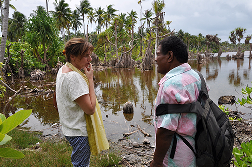 Miljö- och biståndsminister Isabella Lövin och Ngualuenga, borgmästare på Abaing, visar hur saltvattnet tränger in på land och dödar kokospalmer och viktiga grödor. Foto: Regeringen / TT 