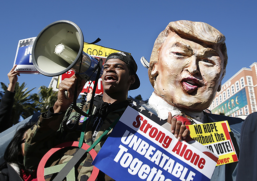 En demonstrant med en pappfigur föreställande Donald Trump. Foto: AP Photo/John Locher