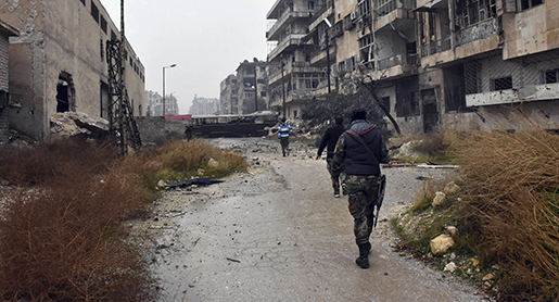 This photo released by the Syrian official news agency SANA, shows Syrian troops and pro-government gunmen marching through the streets of east Aleppo, Syria, Tuesday, Dec. 13, 2016. Syrian rebels said Tuesday that they reached a cease-fire deal with Moscow to evacuate civilians and fighters from eastern Aleppo, after the U.N. and opposition activists reported possible mass killings by government forces closing in on the rebels' last enclave. (SANA via AP)