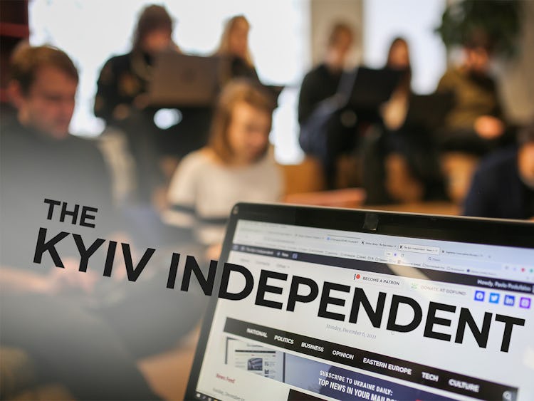 En samling människor, suddigt i bakgrunden, och längst fram del av en datorskärm där en hemsida syns. Över nedre delen av bilden står texten: The Kyiv Independent.
