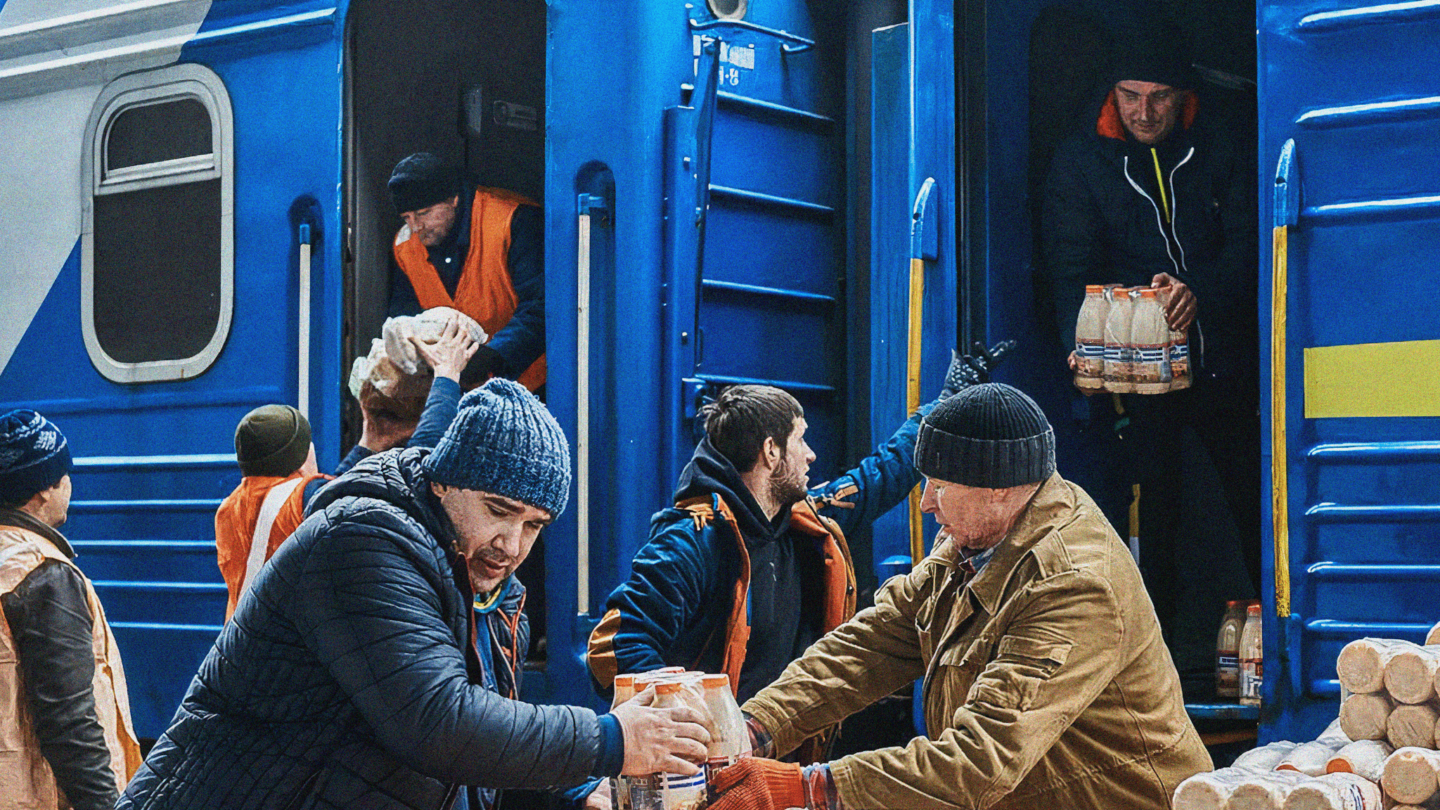 Människor lastar av flaskor med dryck från ett tåg i Ukraina och staplar dem på vagnar.