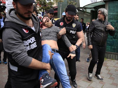 Turkisk polis bär bort en skrikande man från en demonstration.