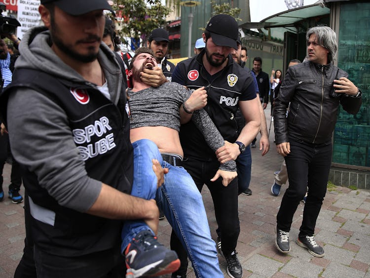 Turkisk polis bär bort en skrikande man från en demonstration.