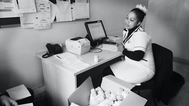 En undersköterska som jobbar med hiv i Malawi sitter vid ett skrivbord