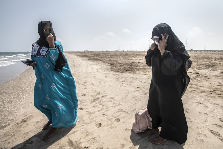 Afrikanska kvinnor som utsatts för trafficking går på en strand i Oman.