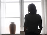 Deprimerad kvinna framför fönster