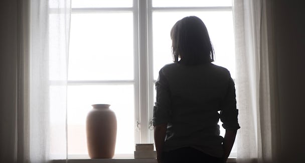 Deprimerad kvinna framför fönster