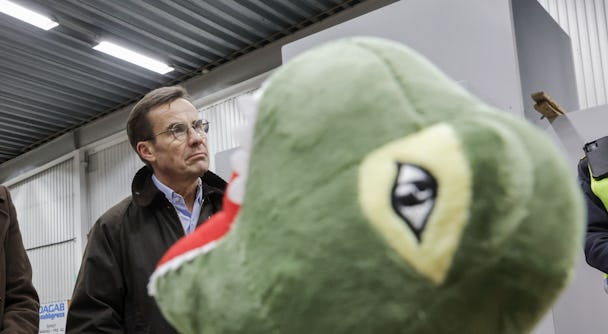 Ulf Kristersson bakom en grön drake.