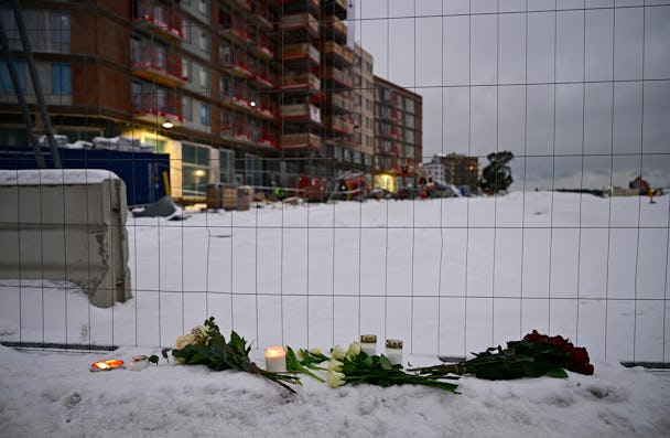 Blommor och ljus utanför byggarbetsplatsen där fem personer dog i en hissolycka.