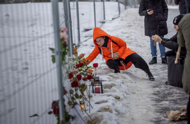 En kvinna lägger ner en blomma vid minnesplatsen för de som dog i hissolyckan.