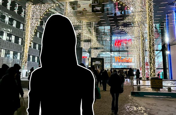 En siluett av en kvinna som står framför en Mall of Scandinavia.