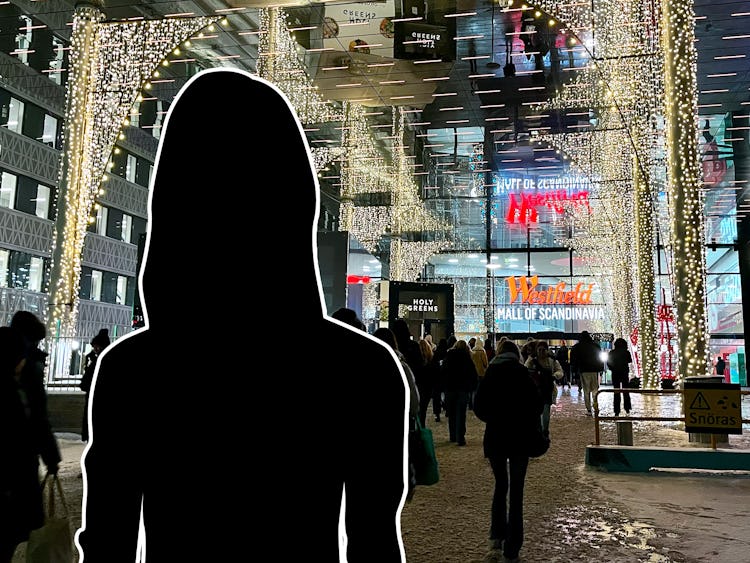 En siluett av en kvinna som står framför en Mall of Scandinavia.