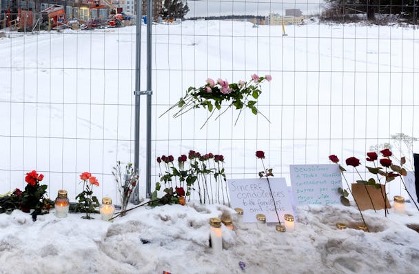 Blommor och ljus vid minnesplatsen för de som dog i hissolyckan.