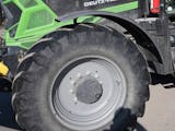 En grön traktor med ett stort däck på.