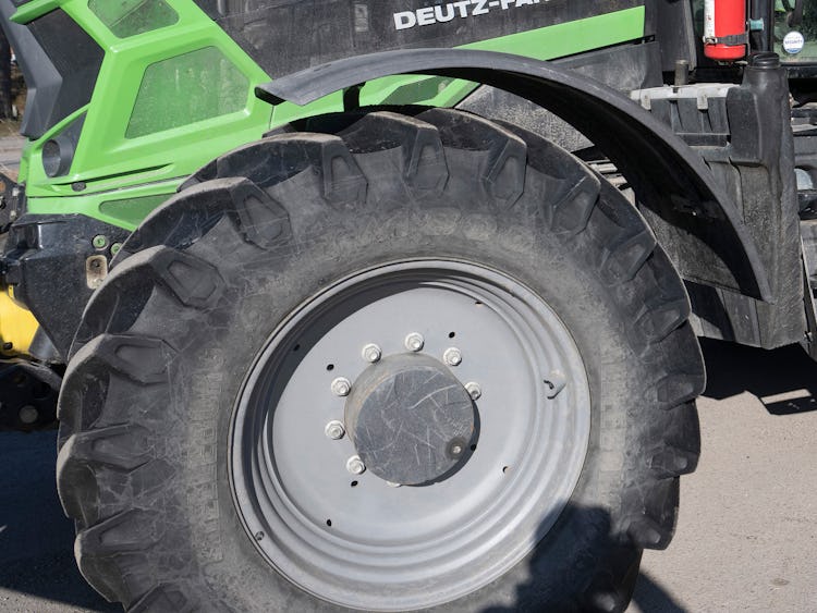 En grön traktor med ett stort däck på.