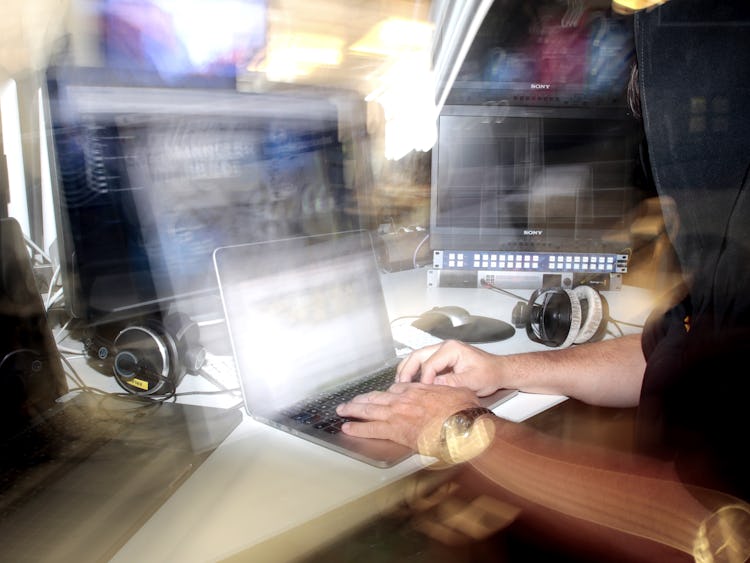 En man i en svart luvtröja som arbetar på en bärbar dator.
