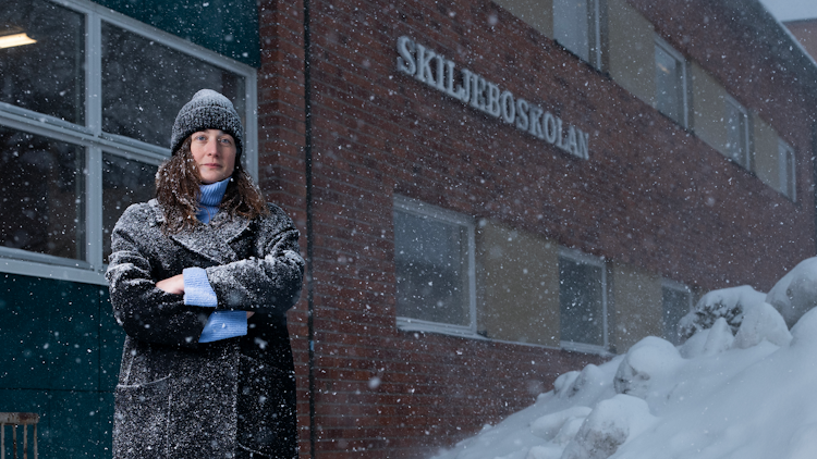 Sophia Hellstrom i en svart rock som står i snön.