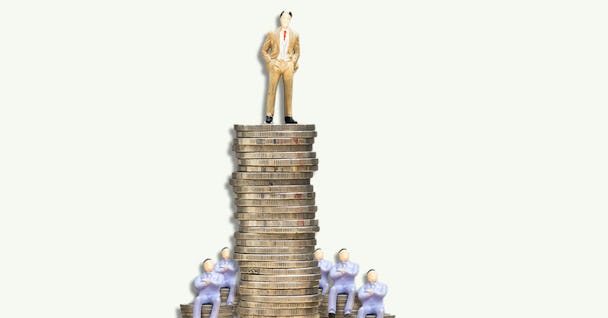 En man som står på toppen av en hög med mynt.