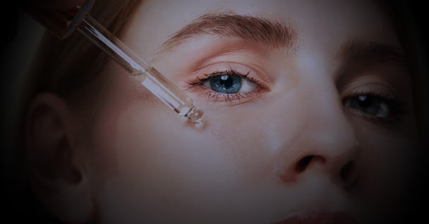 En kvinna som applicerar serum på området under ögonen med en pipett.