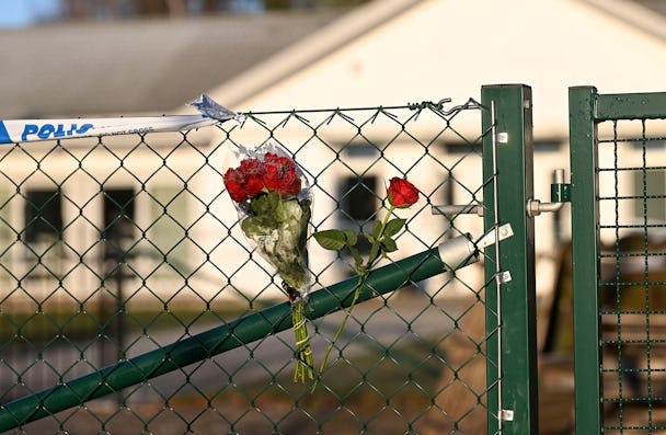 Blommor på stängslet utanför det vårdboende i Enköping där en ung kvinna i personalen dödades.
