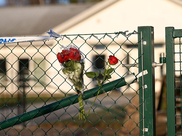 Blommor på stängslet utanför det vårdboende i Enköping där en ung kvinna i personalen dödades.