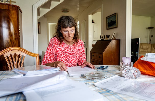 Helena Angvik med en massa dokument på köksbordet.