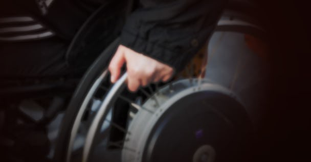 En persons hand på en rullstol.