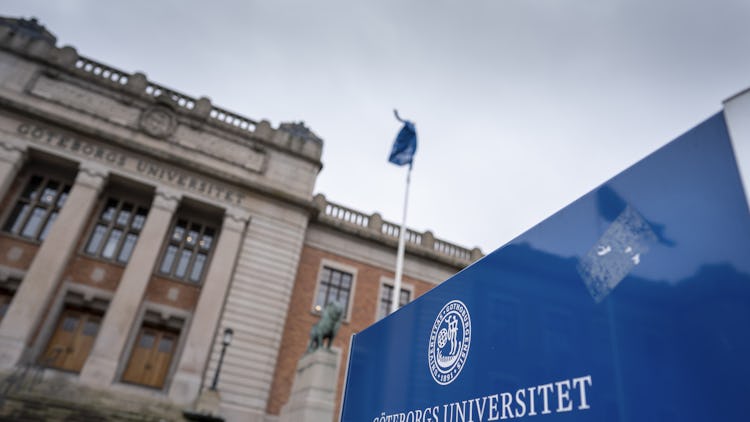 Skylt som visar Göteborgs universitets logotyp i förgrunden, med den historiska universitetsbyggnaden något oskarp i bakgrunden.