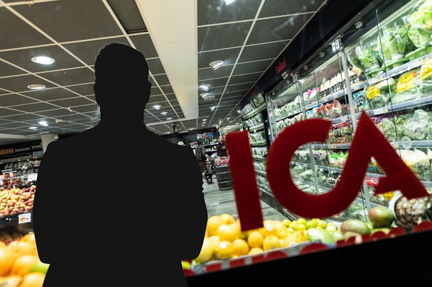 Kontur av en person framför en butiksdisplay med olika frukter och grönsaker i bakgrunden. Bokstäverna "ICA" syns på glaset i förgrunden.