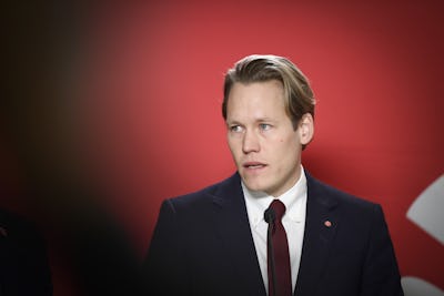 Björn Wiechel Man med kostym, blont hår, slips, röd bakgrund