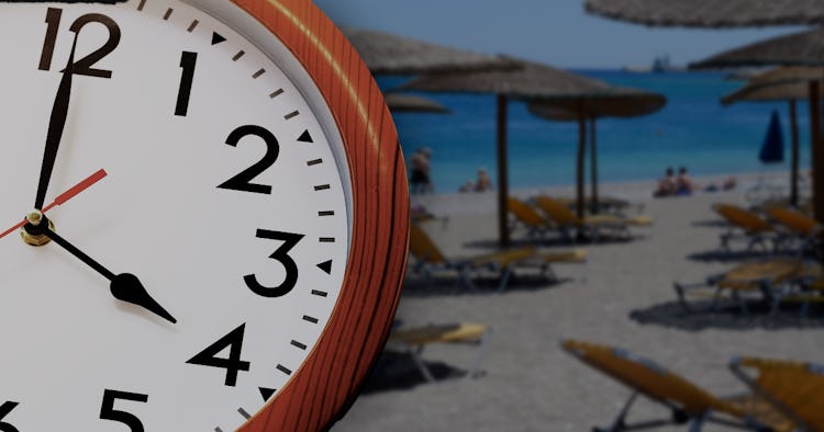 Närbild av en analog klocka som visar 11:02, överlagrad på en suddig bakgrund av en solig strand med flera solstolar och parasoller.