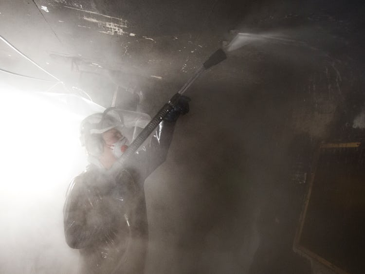 Brandsaneraren Sven-Olof Berglaw använder högtryckstvätt.