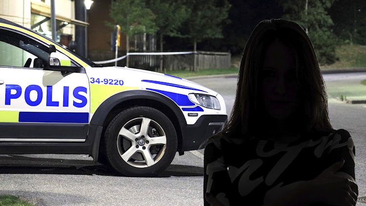 En kvinna står framför en polisbil.