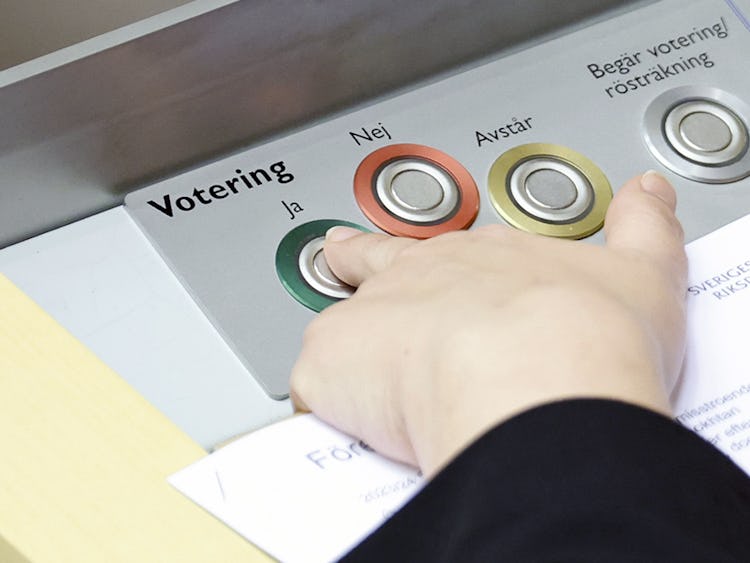 En person som trycker på knappar på en maskin i riksdagen.