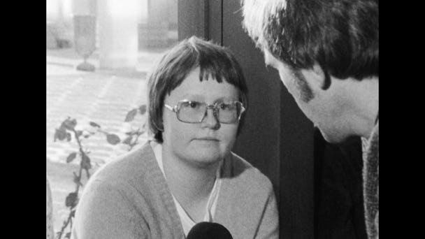 Svartvit arkivbild där Britt-Marie Johansson i gammaldags glasögon intervjuas av en reporter med mikrofon.