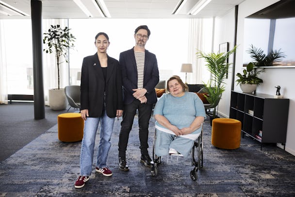 Seher Yilmaz, Erik Hedin, och Maria Johansson (i rullstol) är på ett modernt kontor och tittar in i kameran.
