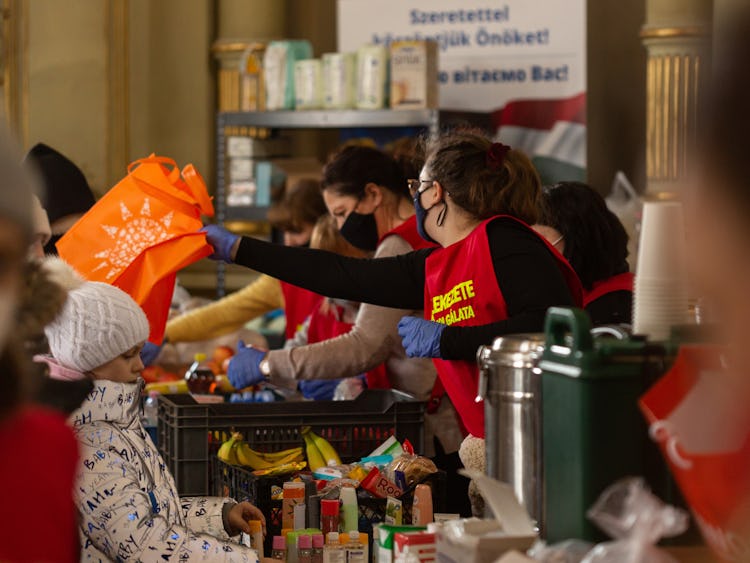 Flyktingar från Ukraina tar emot mat och förnödenheter på centralstationen i Budapest.