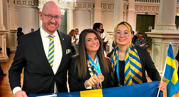 Jasmin Aslan (mitten) vann Medallion of Excellence på Worldskills Frisör-VM i Helsingfors 2022. I bild med Patrik Svensson, Worldskills Swedens tekniska delegat, och tränaren Anna Le.