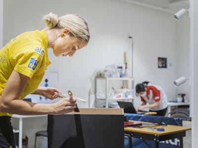Hanna Lind tävlar i VM i visual Merchandising / butikskommunikation. I bilden målar hon kanterna på sitt podium i svart.