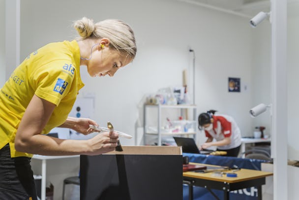 Hanna Lind tävlar i VM i visual Merchandising / butikskommunikation. I bilden målar hon kanterna på sitt podium i svart.