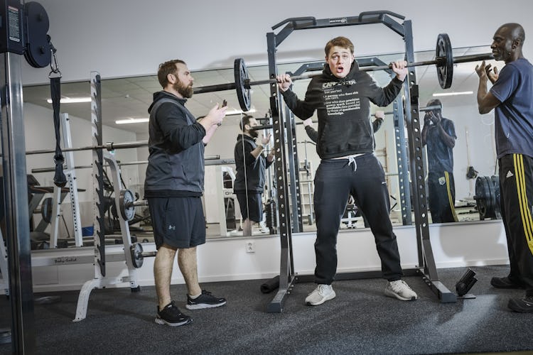 Tre män tränar på ett gym.